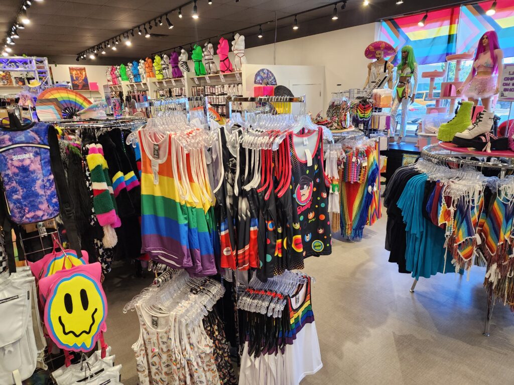 A vibrant clothing store with a wide array of rainbow-colored items on display